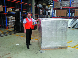 Ron Pierce, MD of Packwest, alongside a pallet of milk wrapped in the company's highly insulating reflective cover.